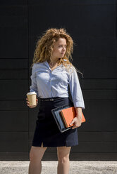 Geschäftsfrau mit Kaffee zum Mitnehmen, Buch und digitalem Tablet im Freien - MAUF000702