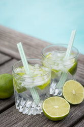 Glasses of infused water with lime and ice cubes - JUNF000547