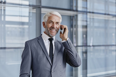 Smiling businessman on cell phone - RORF000236