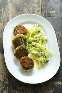 Homemade fish patties with dill, chinese cabbage with cream sauce on plate - ODF001435