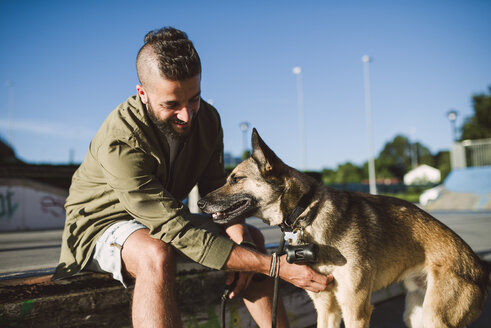 Mann mit seinem Hund in einem Skatepark - RAEF001346