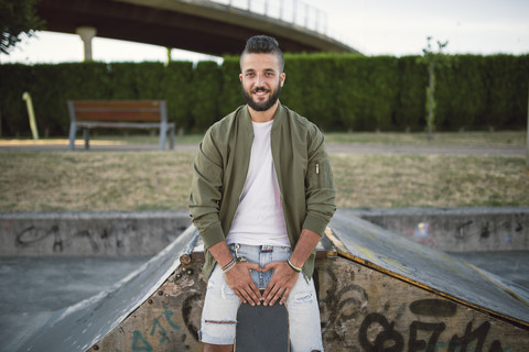 Lächelnder Mann mit Skateboard, lizenzfreies Stockfoto