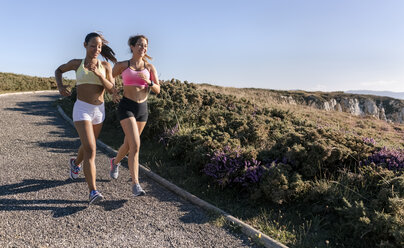 Spain, Asturias, two sportswomen training on the coast, jogging - MGOF002170
