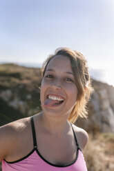 Spain, Asturias, portrait of a sportswoman, smiling, sticking out tongue - MGOF002178