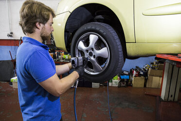 Mechanic fixing a car wheel in a workshop - ABZF000960