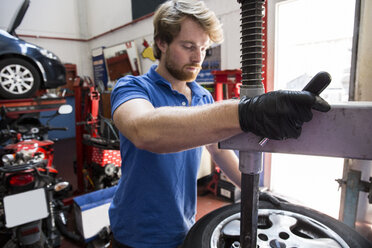 Mechaniker in Autowerkstatt beim Reifenwechsel - ABZF000962