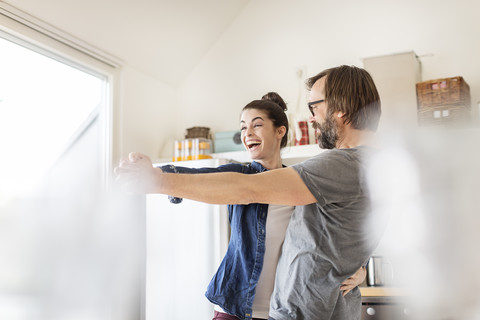 Playful couple dancing in kitchen stock photo