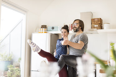 Smiling couple dancing in kitchen - PESF000256