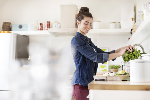 Junge Frau in der Küche bei der Essenszubereitung, lizenzfreies Stockfoto