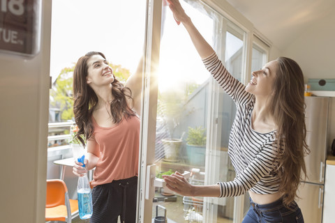 Two women cleaning window together stock photo