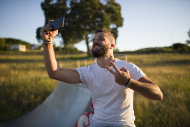 Mann macht Selfie und zeigt Siegeszeichen - RAEF001383