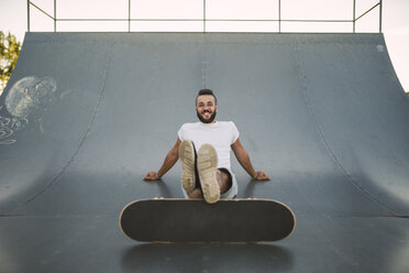 Lächelnder Skateboarder auf einer Rampe in einem Skatepark - RAEF001384