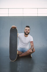 Lächelnder Skateboarder auf einer Rampe in einem Skatepark - RAEF001385