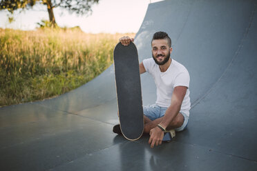 Lächelnder Skateboarder auf einer Rampe in einem Skatepark - RAEF001386