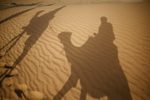 Schatten von Menschen auf Kamelen in der Wüste - KIJF000698