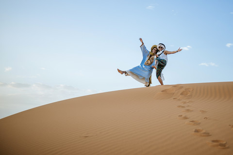 Berber Mann und Frau Tourist Gruß in der Wüste, lizenzfreies Stockfoto