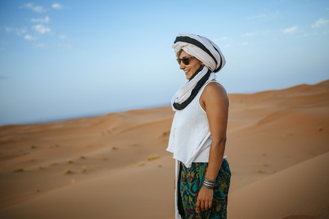 Frau in der Wüste stehend, mit Turban, lizenzfreies Stockfoto