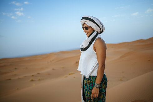 Frau in der Wüste stehend, mit Turban - KIJF000708