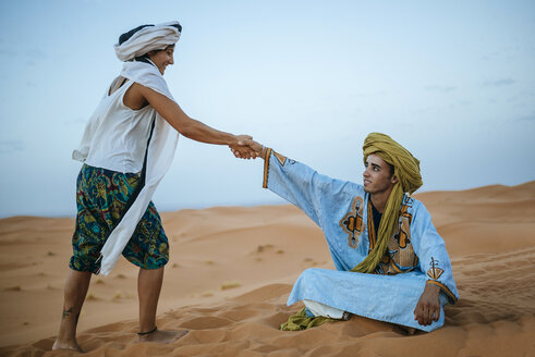 Frau hilft ihrem Berberführer beim Aufstehen - KIJF000716