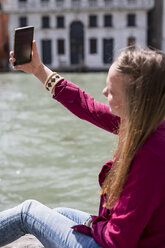 Italy, Venice, tourist taking selfie with smartphone - MAUF000719