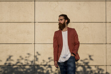 Fashionable young man leaning against wall in the sunlight - MAUF000724