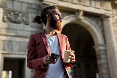 Junger Mann mit Kaffee und Smartphone schaut in die Ferne - MAUF000738