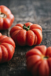 Four homegrown organic oxheart tomatoes on dark wood - IPF000324