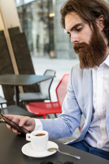 Stilvoller Geschäftsmann benutzt Handy in einem Café - MAUF000748