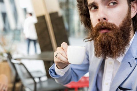 Stilvoller Geschäftsmann trinkt Espresso in einem Cafe, lizenzfreies Stockfoto