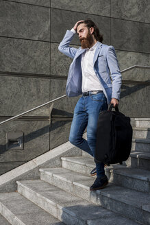Stilvoller Geschäftsmann geht mit Koffer auf Treppe im Freien - MAUF000758