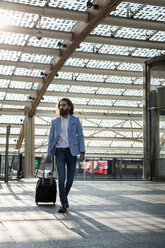 Stylish businessman walking with suitcase - MAUF000771