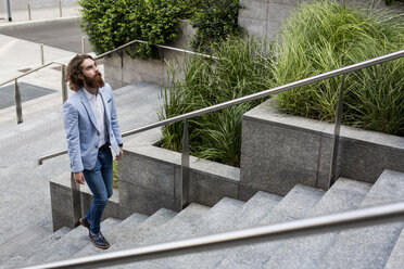 Stylish businessman walking on stairs outdoors - MAUF000773
