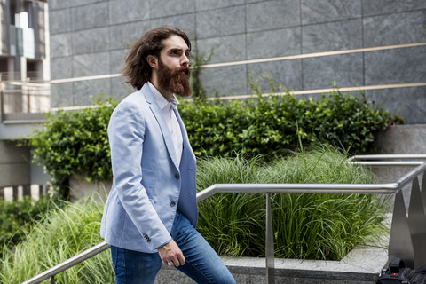 Stylish businessman walking on stairs outdoors stock photo