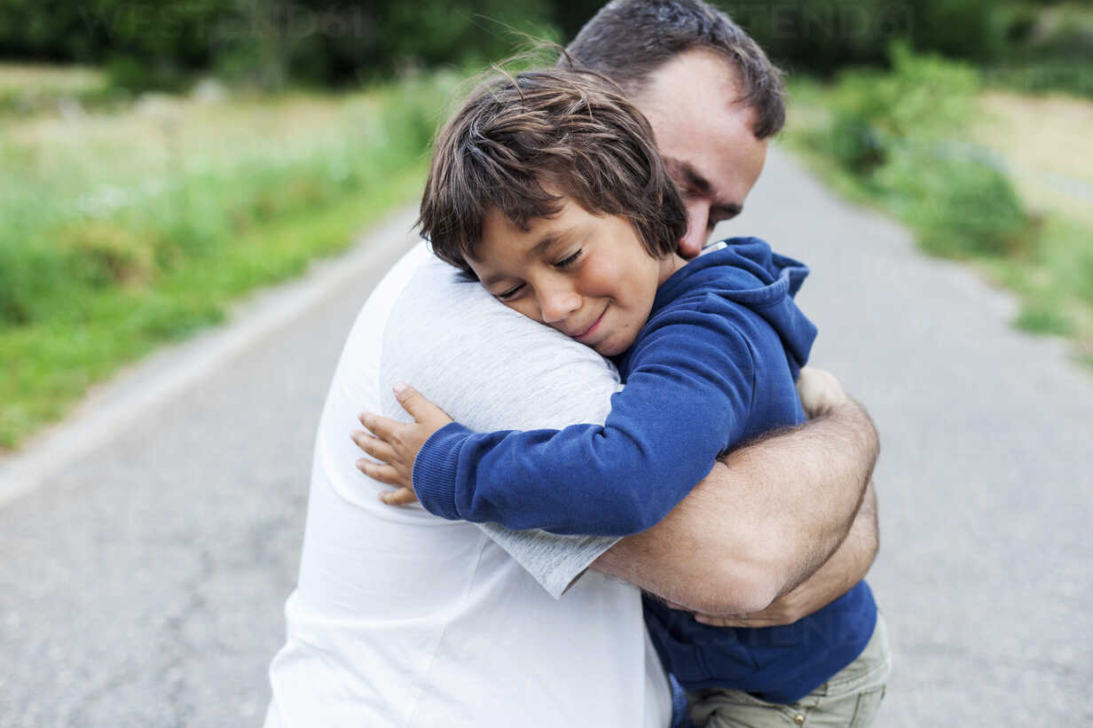 Happy father and little son hugging each other stock photo