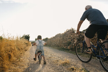 Rückenansicht eines kleinen Jungen und seines Urgroßvaters bei einer Fahrradtour - JRFF000811