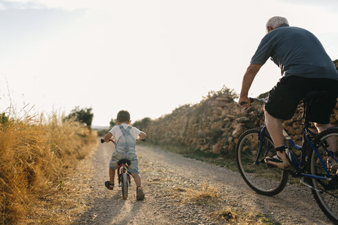Back view of little boy and his great-grandfather on bicycle tour - JRFF000811