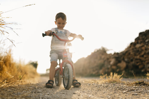 Kleiner Junge mit Kinderfahrrad auf Feldweg - JRFF000814