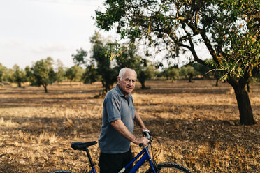 Senior man with bicycle on a field - JRFF000821