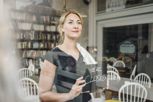 Frau in einem Café, die das Schild 