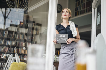 Frau in einem Café mit geschlossenem Schild - KNSF000208