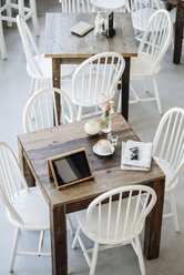 Digitales Tablet, Sonnenbrille, Zeitung und Tasse Kaffee auf dem Tisch in einem Café - KNSF000214