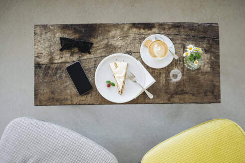 Handy, Sonnenbrille, Kuchen und Tasse Kaffee auf dem Tisch in einem Café - KNSF000225