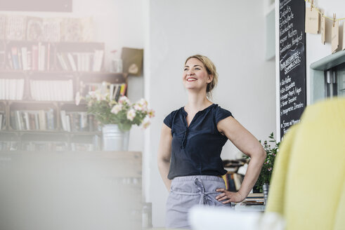 Lächelnde Frau in einem Cafe - KNSF000227