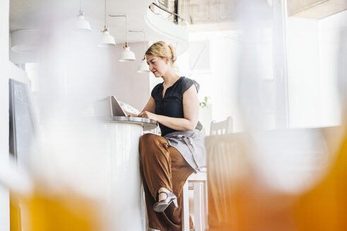 Frau benutzt digitales Tablet in einem Café - KNSF000228