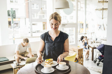 Kellnerin in einem Café, die Kuchen und Kaffee serviert - KNSF000235