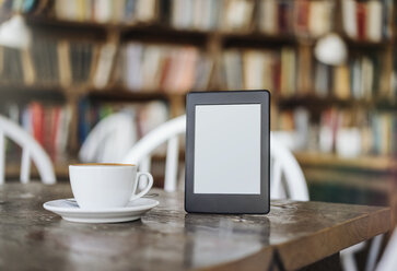 E-Book und Tasse Kaffee auf dem Tisch in einem Café - KNSF000236