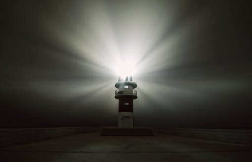 Spanien, Carino, strahlender Leuchtturm in einer nebligen Nacht - RAEF001407