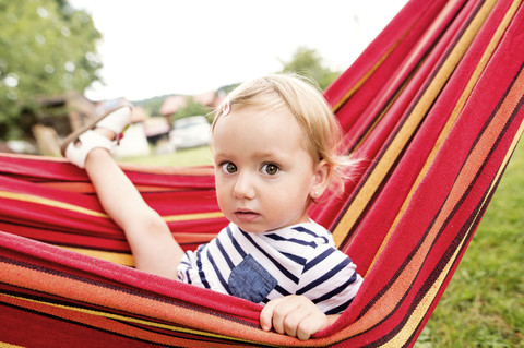 Kleines Mädchen in Hängematte sitzend, lizenzfreies Stockfoto