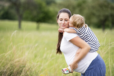 Mother carrying daughter piggyback - HAPF000718