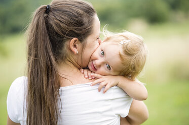 Mother kissing at hugging her little daughter - HAPF000720